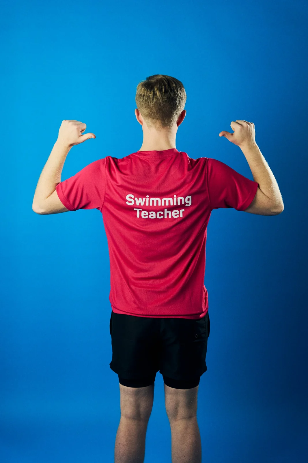 Jack Ruddle showing the Swimming Teacher text on the back of his shirt.